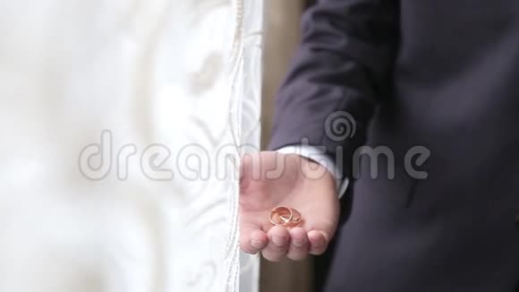 穿黑色西装的新郎手里拿着结婚戒指视频的预览图