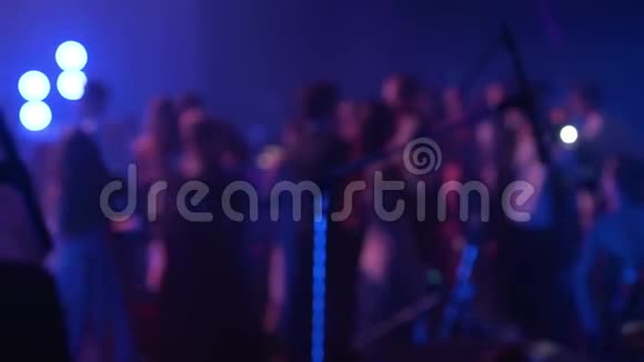 在音乐音乐会上人们在舞池的夜总会里缓慢地随着电子音乐跳舞模糊的轮廓视频的预览图