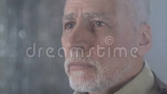 老人用餐巾擦眼泪看着外面的雨天痛苦视频的预览图