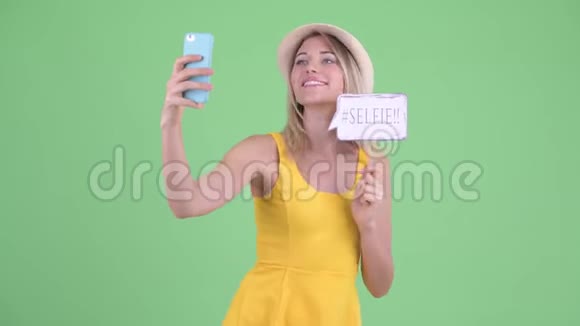 一位年轻的金发美女带着纸签自拍视频的预览图