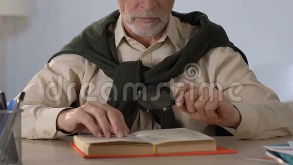 老年人通过放大镜阅读书籍老年视力障碍视频的预览图