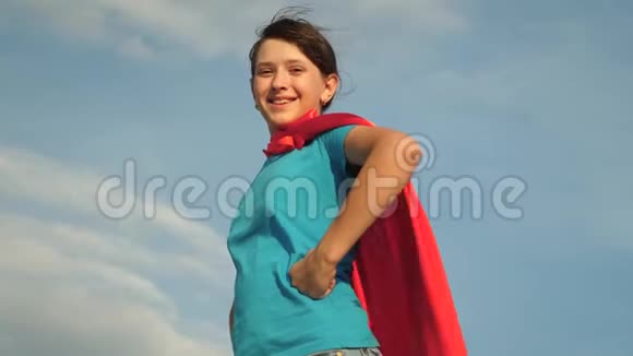 少女超级英雄穿着红色斗篷站在田野上斗篷迎风飘扬慢动作女孩的梦想视频的预览图