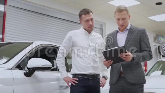 汽车经销商向买车的人解释销售合同视频的预览图
