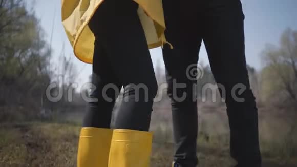 描绘了一对年轻可爱的夫妇在城外的河边散步穿着黄色衣服的金发美女视频的预览图