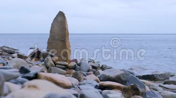 大自然的背景有一大块岩石在海上野生海滩的石头视频的预览图