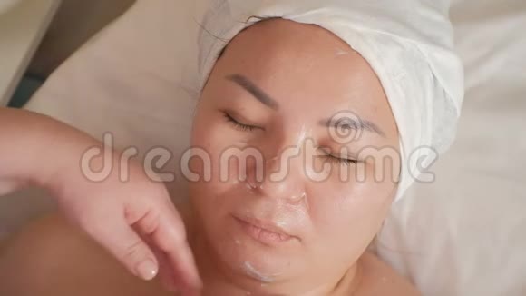 展示女性面部美容后的变化按摩治疗师美容师的手视频的预览图