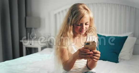 女孩在卧室的智能手机上发短信视频的预览图
