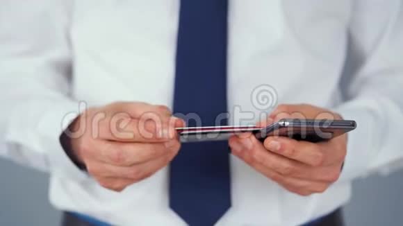 正式穿着的男人从几张信用卡中选择一张信用卡并将其号码输入智能手机以在线支付网上在线视频的预览图