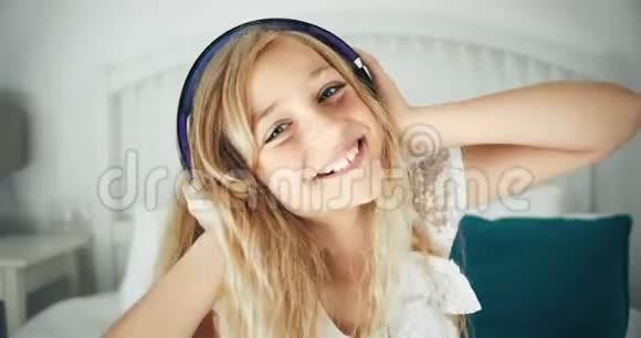 戴着耳机在床上玩的女孩视频的预览图
