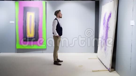 一个人在博物馆大厅里观看抽象的艺术品视频的预览图
