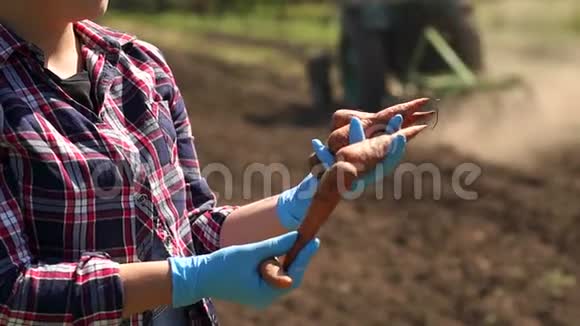 农夫正拿着一根胡萝卜在田里一辆工作拖拉机的背景上视频的预览图