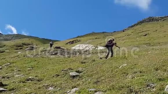 登山旅行者爬上小山视频的预览图
