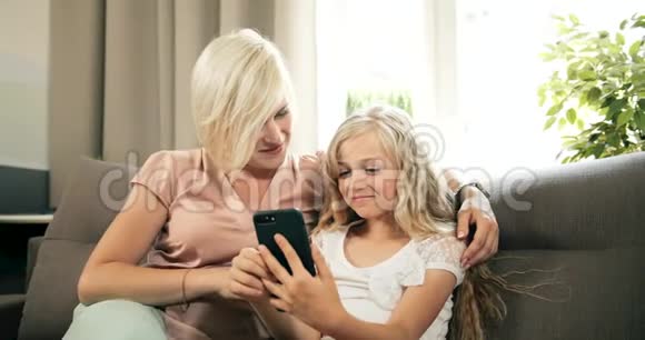 母亲和女儿扫描智能手机视频的预览图