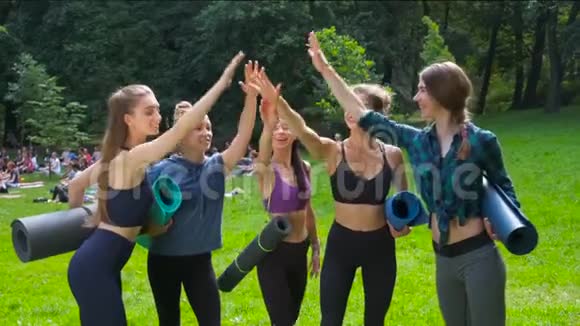 一群女朋友在户外晨训后把手放在公园里积极的生活方式视频的预览图