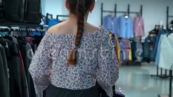 有孩子的年轻女子去商店挑选衣服视频的预览图