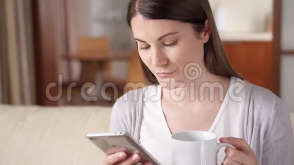 微笑的女商人在家里用手机喝咖啡家庭办公概念视频的预览图