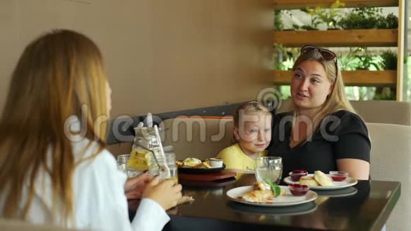 母亲与孩子在咖啡厅与朋友会面视频的预览图
