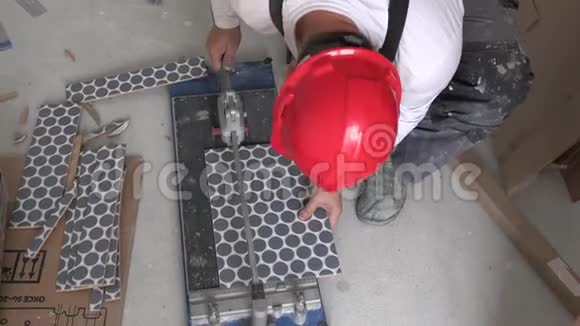 带防护头盔的男主人用特殊工具切割瓷砖视频的预览图