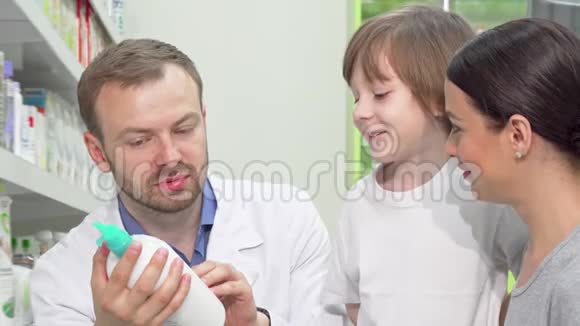 快乐的男药师帮助小儿子的年轻女子视频的预览图