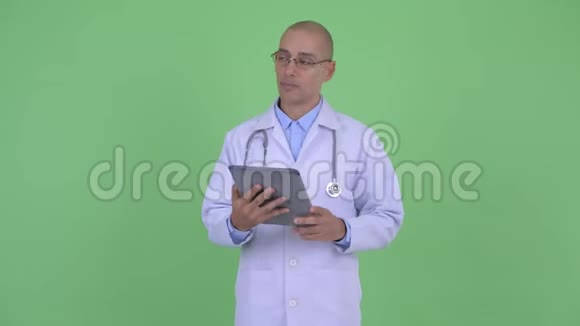 快乐秃顶多民族医生用数码平板电脑思考视频的预览图