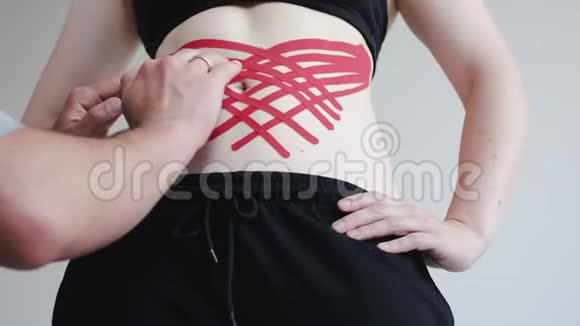 临床上治疗师将运动学磁带贴在妇女肩膀上视频的预览图