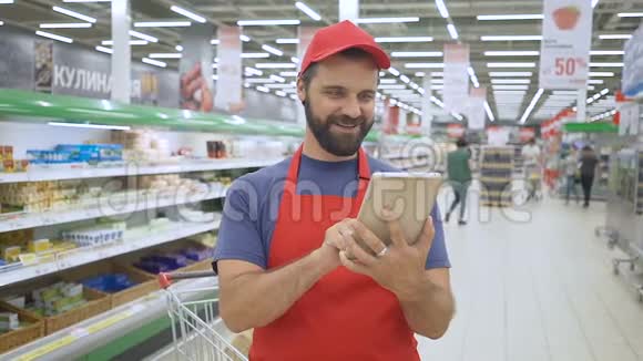 超市里的快乐售货员用数码平板电脑视频的预览图