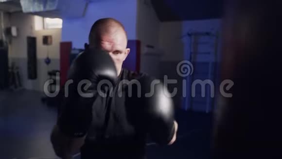 拳击手在一个拳击袋上缓慢地工作摇动相机视频的预览图