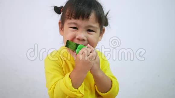 一个快乐微笑的亚洲儿童女孩的肖像享受吃西瓜孤立在白色背景视频的预览图