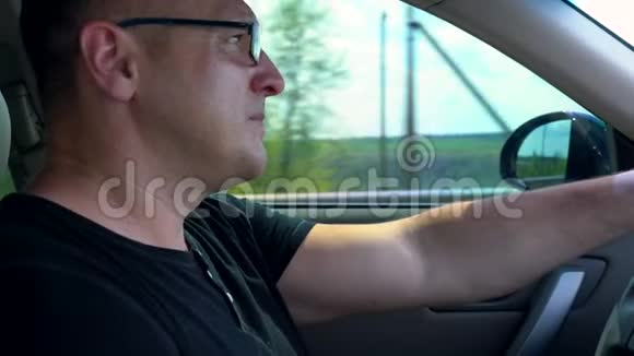 一个戴眼镜的人在长途旅行中开车视频的预览图