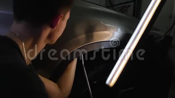 PDR油漆凹痕修复拆除一个年轻人在没有油漆的情况下用钢钩打了个凹痕然后用一个特殊的炉子取暖视频的预览图