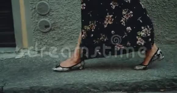 细节行走的女人的腿在街上她穿着一件浪漫的长裙外面有点风视频的预览图