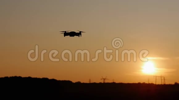 乡村夕阳西下一架四翼飞机在天空中飞翔在田野里无人驾驶视频的预览图