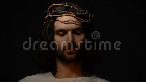 耶稣在荆棘的冠冕上举着蜡烛拯救恩典宗教的标志视频的预览图