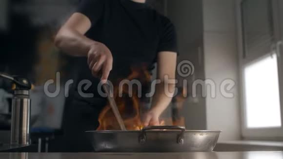 厨师用慢动作的热气腾腾的炒锅炒亚洲食物烹饪中国菜在热锅里搅拌厨房的厨房视频的预览图