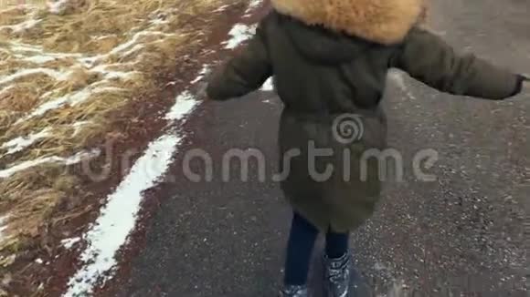 小女孩在寒冷的冬日学习滑板的基本知识视频的预览图