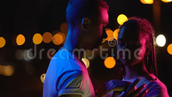 可爱的少女情侣拥抱夜晚的灯光享受浪漫的气氛视频的预览图