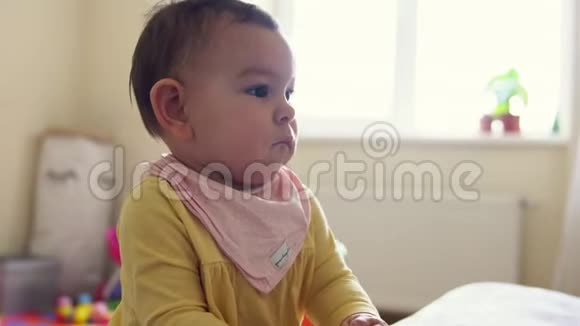 小宝宝蹒跚学步站在沙发附近严肃而平静视频的预览图