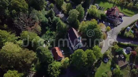 一栋被高大的绿树环绕的房子的俯视图晴天4k视频的预览图