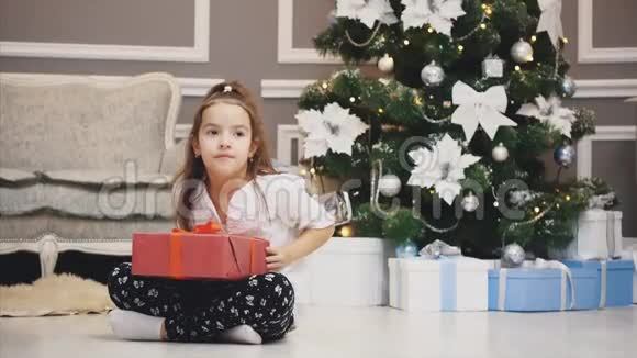 广告视频小女孩得到了一个礼品盒并呈现在相机前面的圣诞节背景视频的预览图