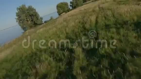 FPV无人机赛车视野在土路和田野上的动态飞行视频的预览图