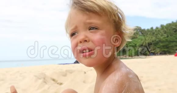 体贴的男孩坐在沙滩上视频的预览图