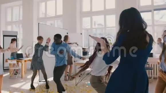 快乐的年轻多民族创业公司的同事们庆祝在激动人心的办公室聚会上跳舞的成就视频的预览图