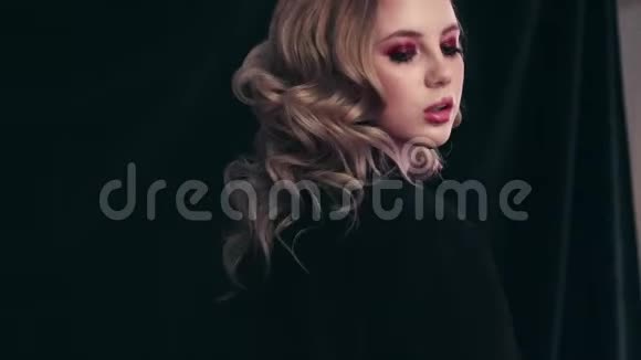 漂亮的女孩模特金发卷发和明亮的化妆姿势在相机上视频的预览图