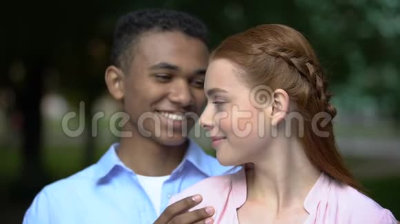 拥抱多民族的青少年夫妇抱着纸心温柔的关系爱视频的预览图