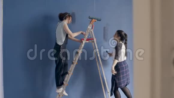 快乐的女性朋友在家边跳边画墙视频的预览图