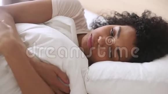沮丧沮丧的非洲妇女感到悲伤独自躺在床上视频的预览图