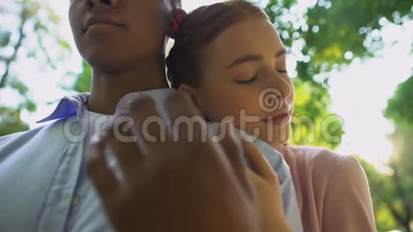 公园里一对年轻夫妇的特写镜头少女靠在男友的肩膀上爱视频的预览图