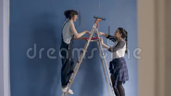 两个女朋友装饰他们的新公寓唱歌跳舞和画墙视频的预览图