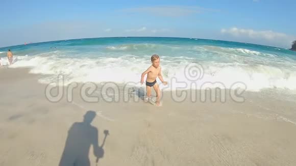 一个小男孩在热带海滩玩的慢镜头夏季概念视频的预览图