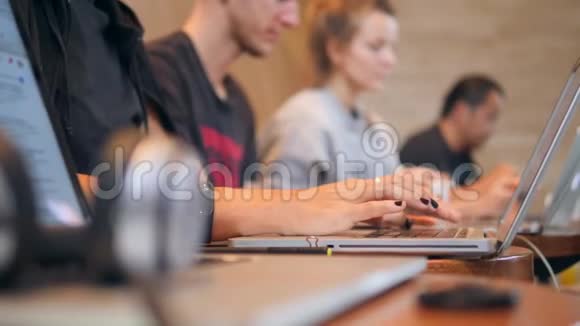 在咖啡店用笔记本电脑键盘打字学生的手4K视频的预览图